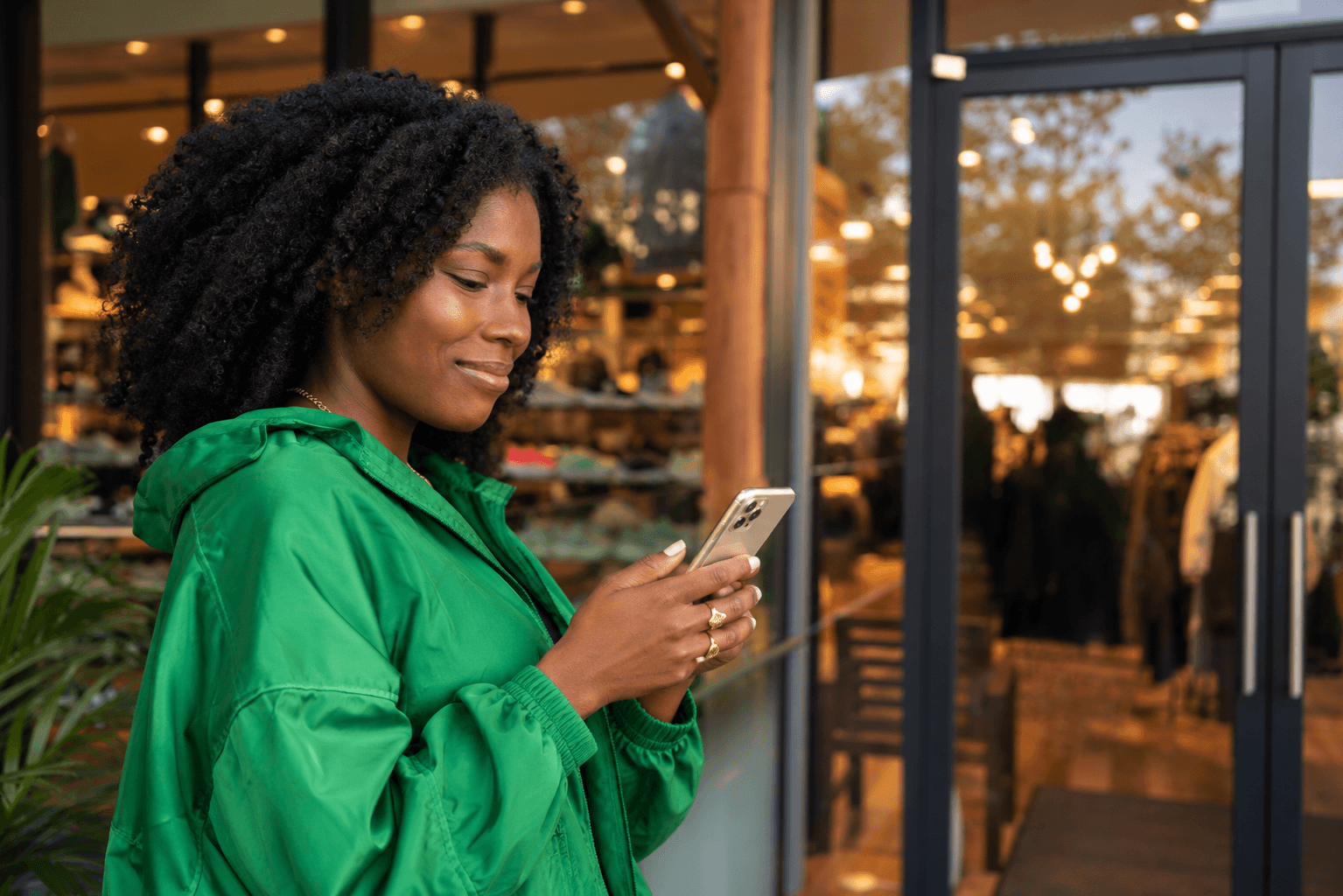 Customer checking SMS notifications on phone outside boutique cafe